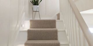 Striped carpet going up Victorian stairs
